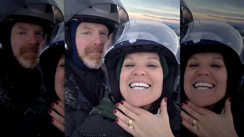 Leslie Davis and Don Reidy wearing helmets as Leslie shows off her ring.