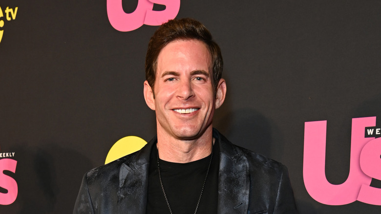 Tarek El Moussa smiling in a black blazer at an Us Weekly event