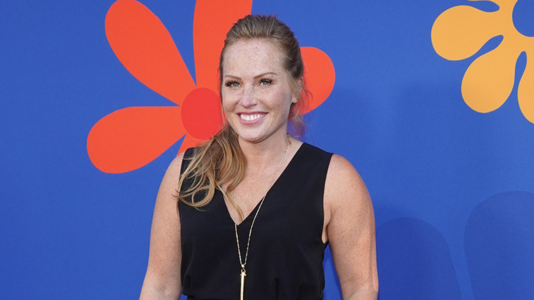 Mina Starsiak Hawk smiling in a black dress at an event
