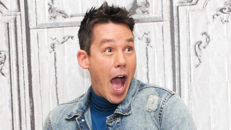 David Bromstad in a denim jacket with his mouth agape in faux shock