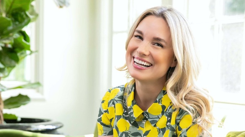 Grace Mitchell (wearing yellow and green) smiling in a photo