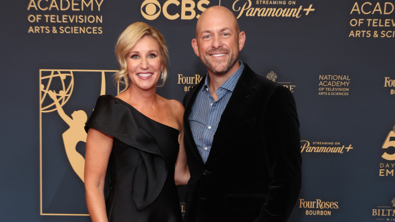 Jenny Marrs wearing a black one-shoulder dress; Dave Marrs wearing a black jacket and blue-striped shirt
