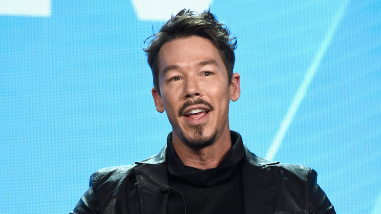 David Bromstad black suit light blue background