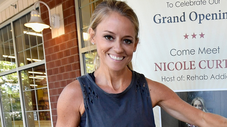 Nicole Curtis smiling and extending left arm