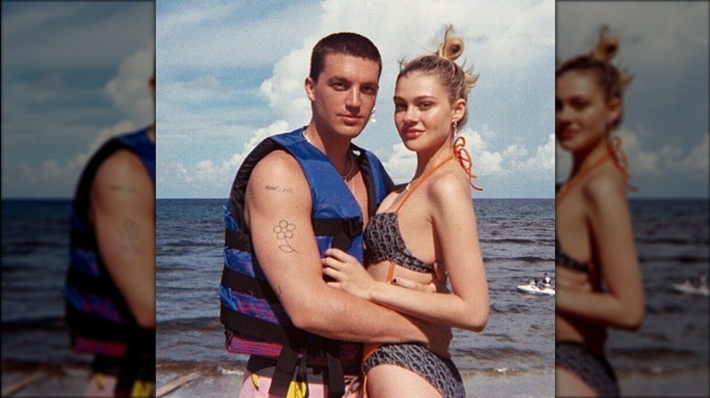 Paul Klein and Nicola Petz standing on beach with arms around each other
