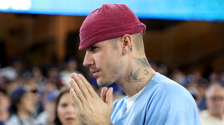 Justin Bieber side profile with hands together in front of him