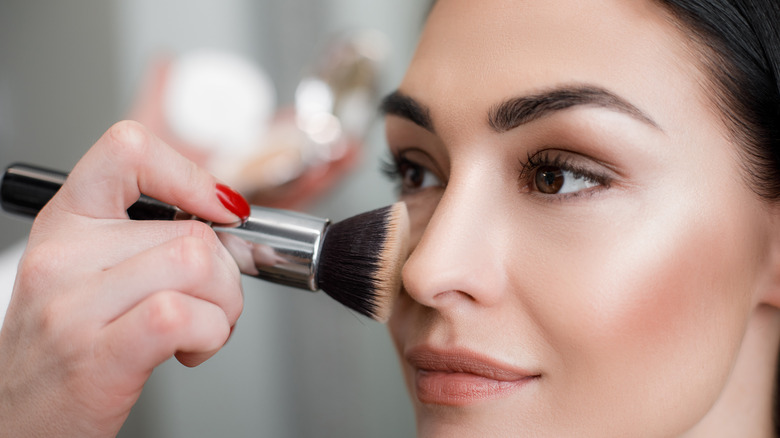 woman applying highlighter