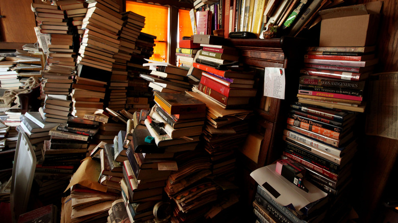 Pile of books in a bedroom.
