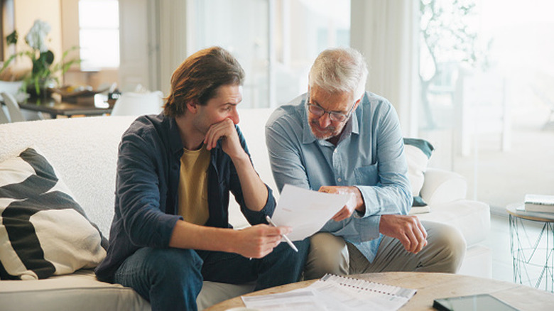 Older man and son looking at a document together