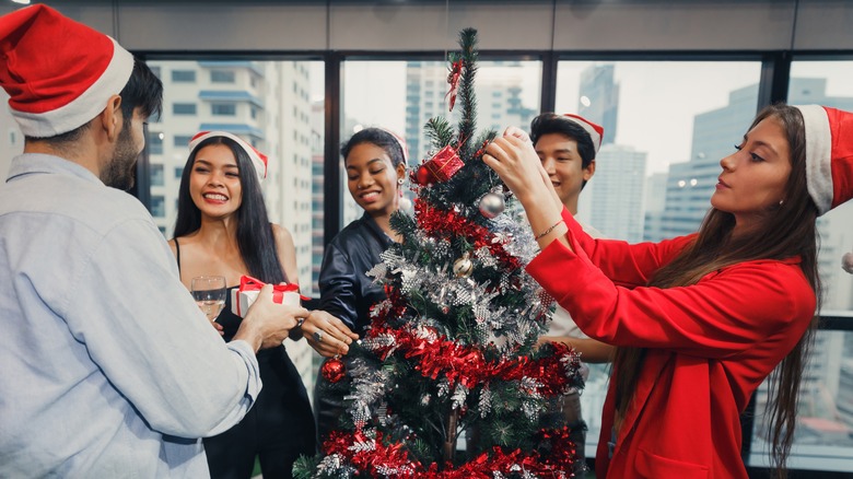 People decorating office Christmas tree