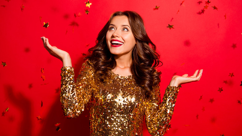 Woman smiling and gold confetti in the air