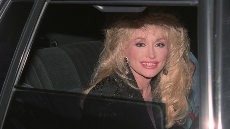 Dolly Parton smiling in a car
