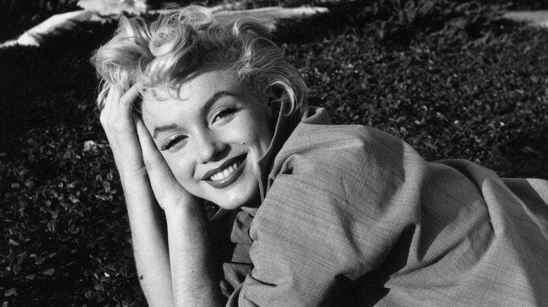 Marilyn Monroe poses outdoors for a black-and-white photo
