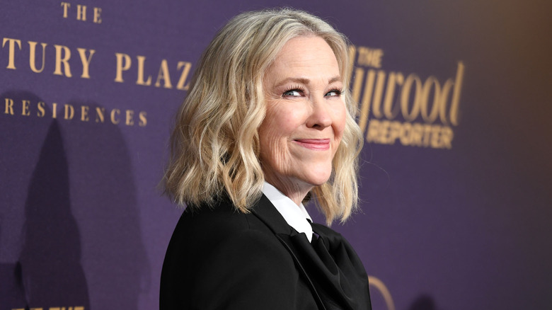 Catherine O'Hara wearing black and looking to the side