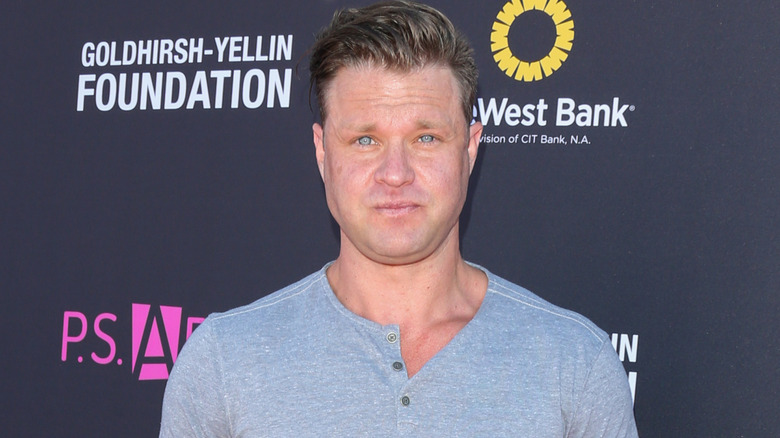 Zachery Ty Bryan posing for photos in a grey sweatshirt