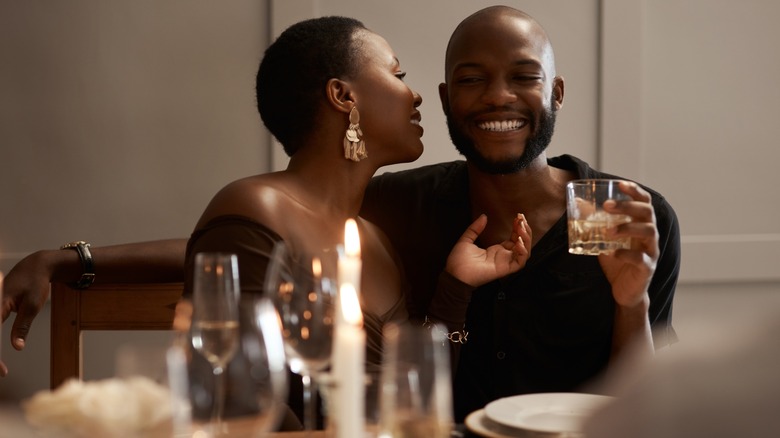 smiling couple at candlelit dinner