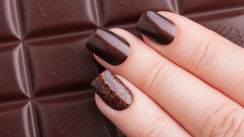 chocolate brown nails holding chocolate