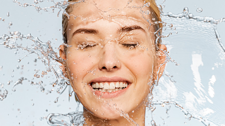 Smiling woman splashing water