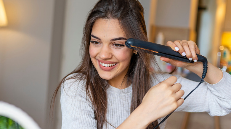 Woman straightening her hair