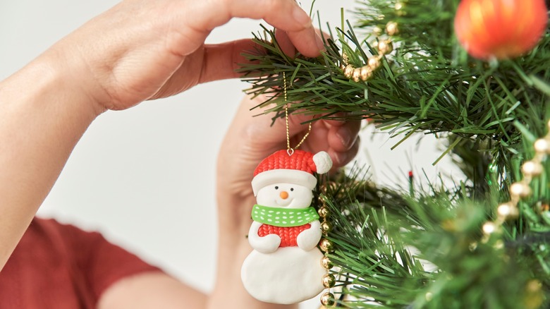 A woman decorating a Christmas tree 