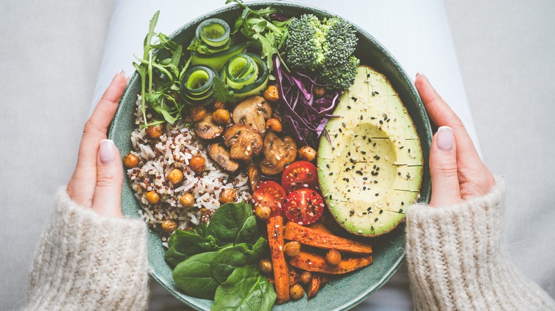 Woman holding a plant-based meal in a bowl