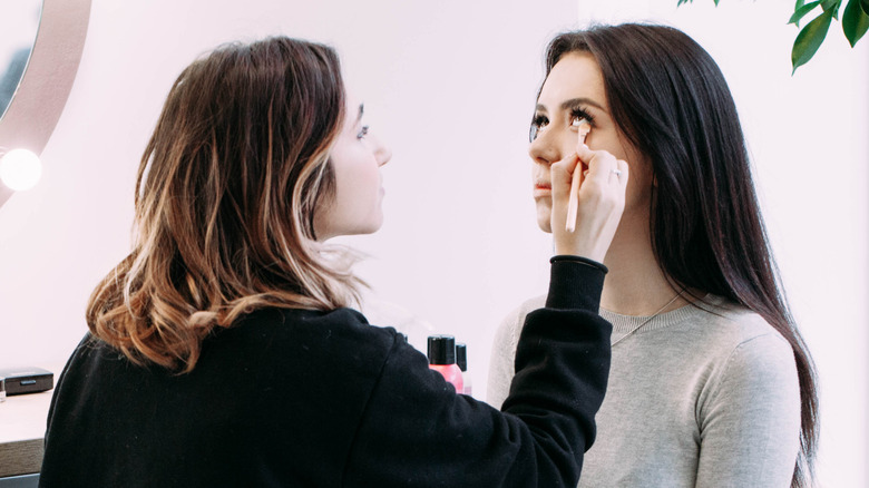 person applying makeup with angled brush