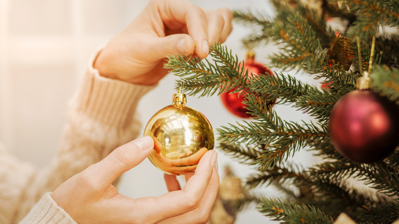 A woman decorating a Christmas tree 