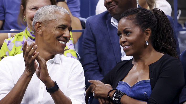 Barack and Michelle Obama smiling and clapping 