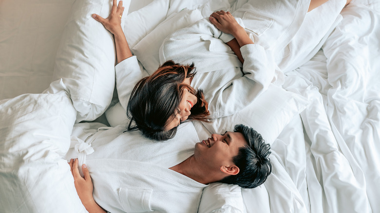 Couple in robes laying in bed