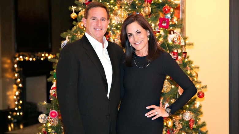 Mark and Paula Hurd posing in front of a Christmas tree