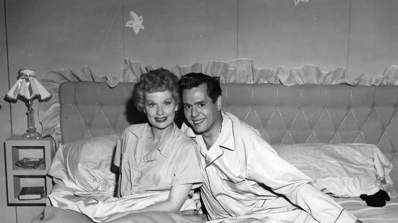 Black and white photo of Lucille Ball and Desi Arnaz wearing pajamas in bed