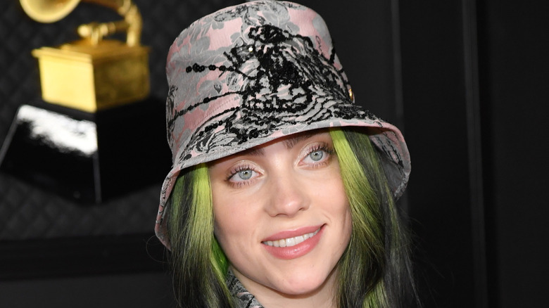 Billie Eilish rocks a bucket hat while holding her Grammys.