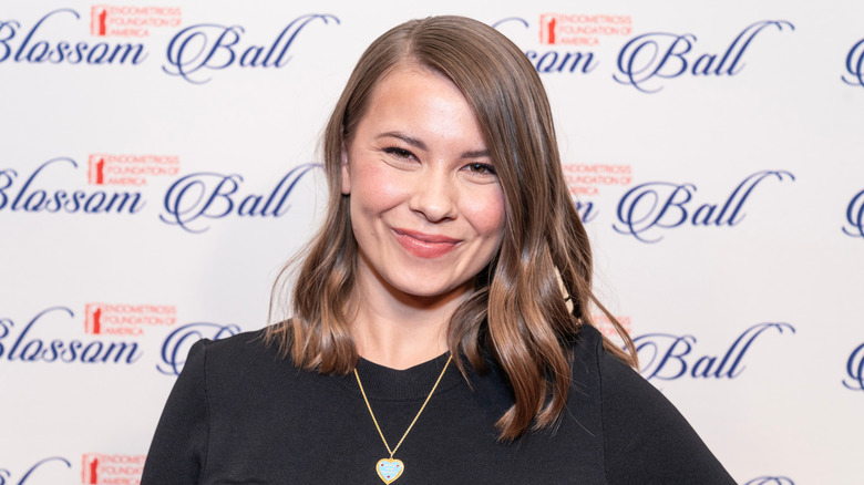 Bindi Irwin smiles in a black dress