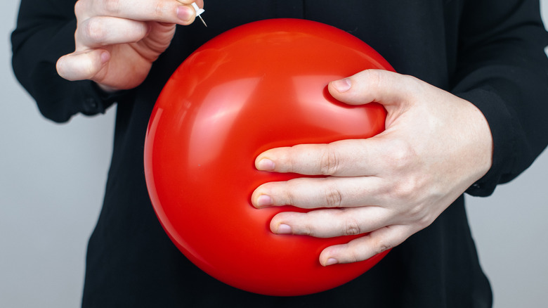 Woman with balloon in front of belly