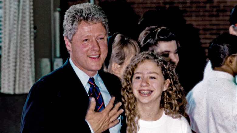 Young Chelsea Clinton smiling with her dad