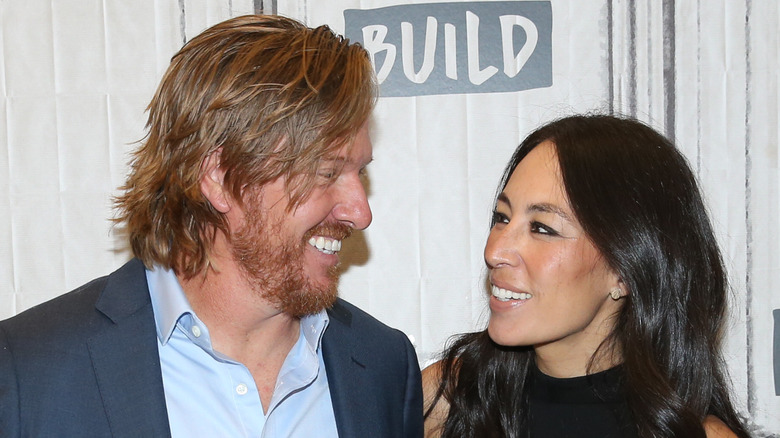 Chip and Joanna Gaines smiling at each other
