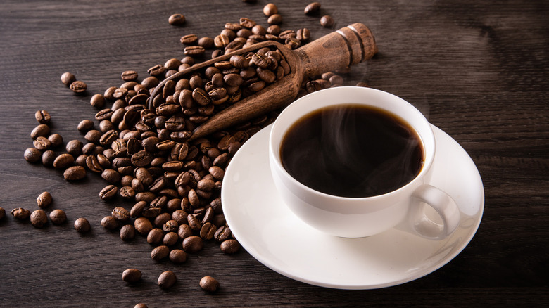 A cup of coffee with coffee beans