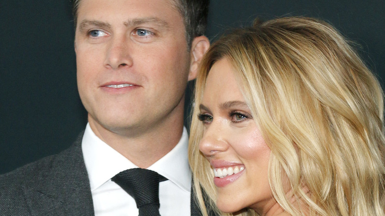 Colin Jost and Scarlett Johansson smiling at a premiere 