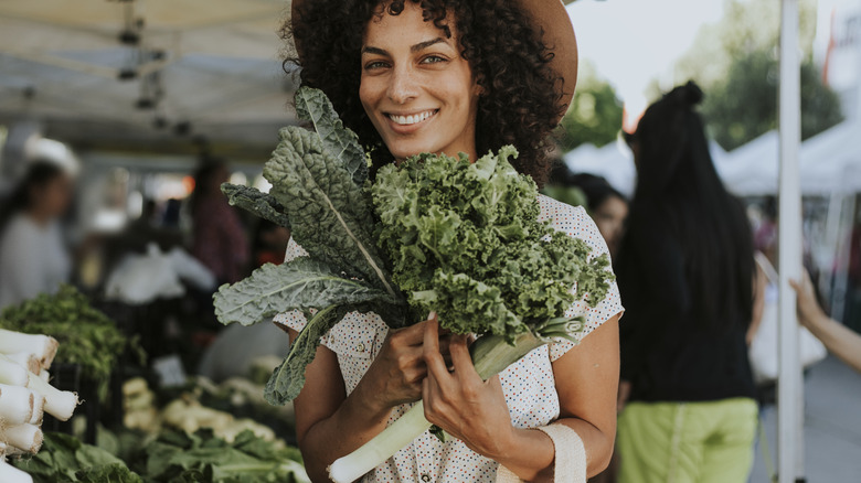Woman at farmer's market holding kale