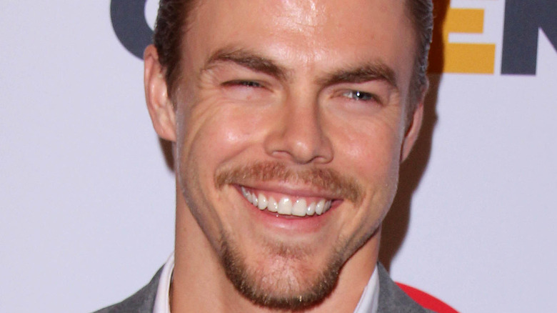 Derek Hough smiling on red carpet