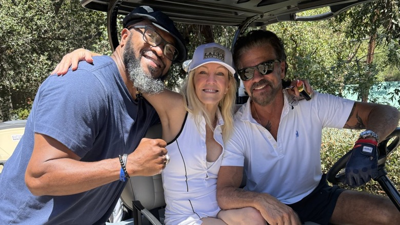 Lamon Brewster, Heather Locklear, and Lorenzo Lamas posing for a photo on a golf cart.