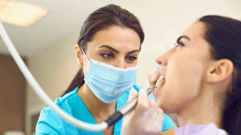 Dental hygienist works on patient in chair