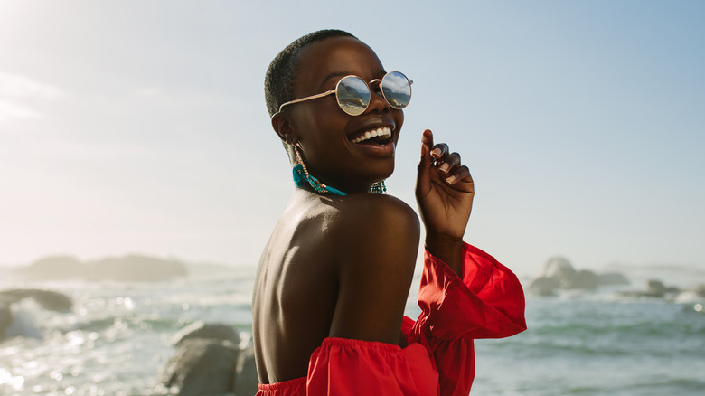 Woman on the beach wears sunglasses
