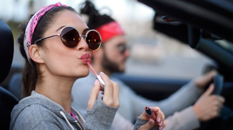 Woman applying lipgloss