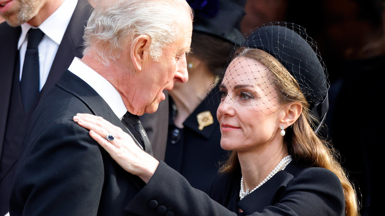 Princess Catherine placing a hand on King Charles III's shoulder