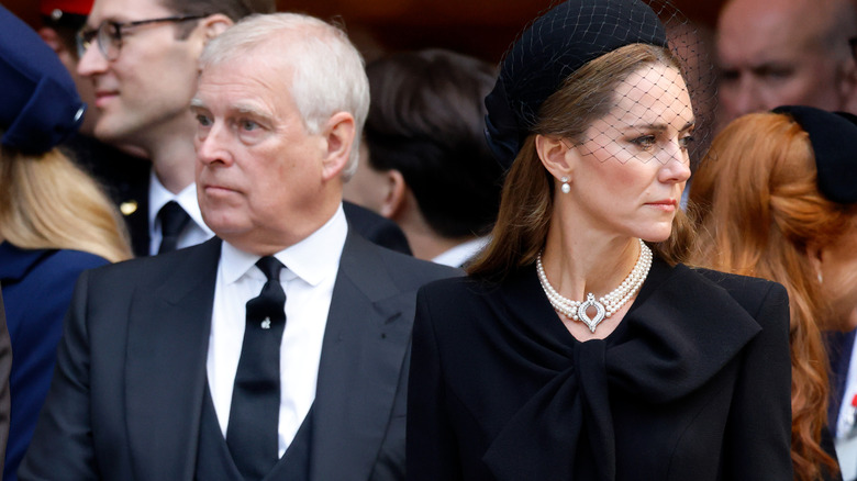 Prince Andrew and Princess Catherine facing away from each other with grim expressions