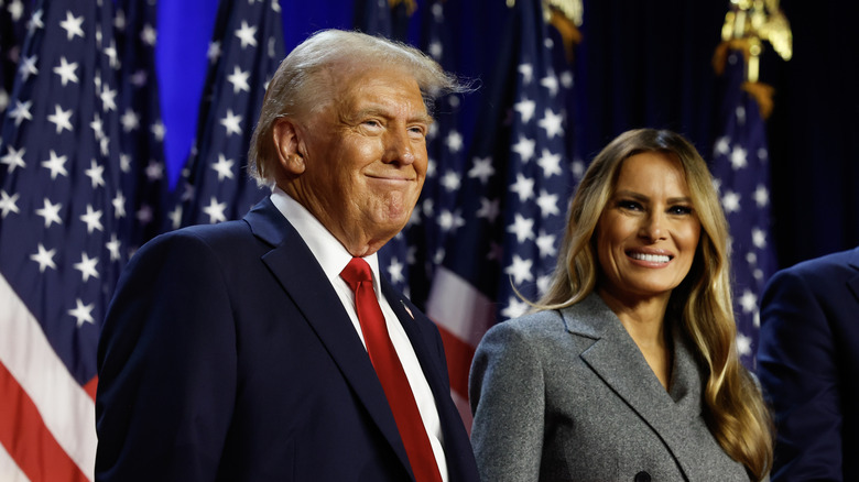 Donald Trump smiles standing next to Melania Trump