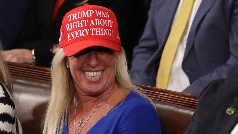 Marjorie Taylor Greene smiling in red 'Trump Was Right' cap with her hair done