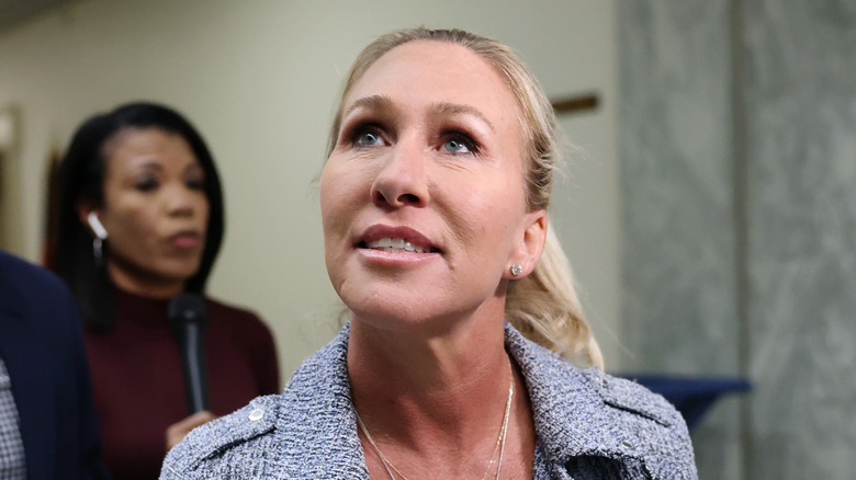 Marjorie Taylor Greene looking up with her hair tied back in a ponytail