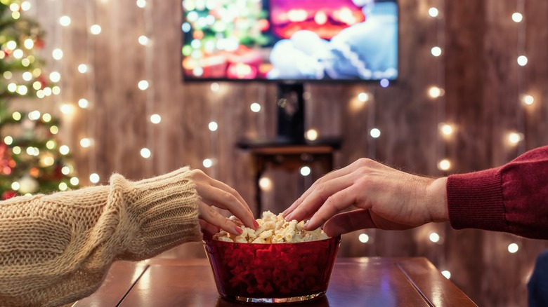 grabbing popcorn while watching movie